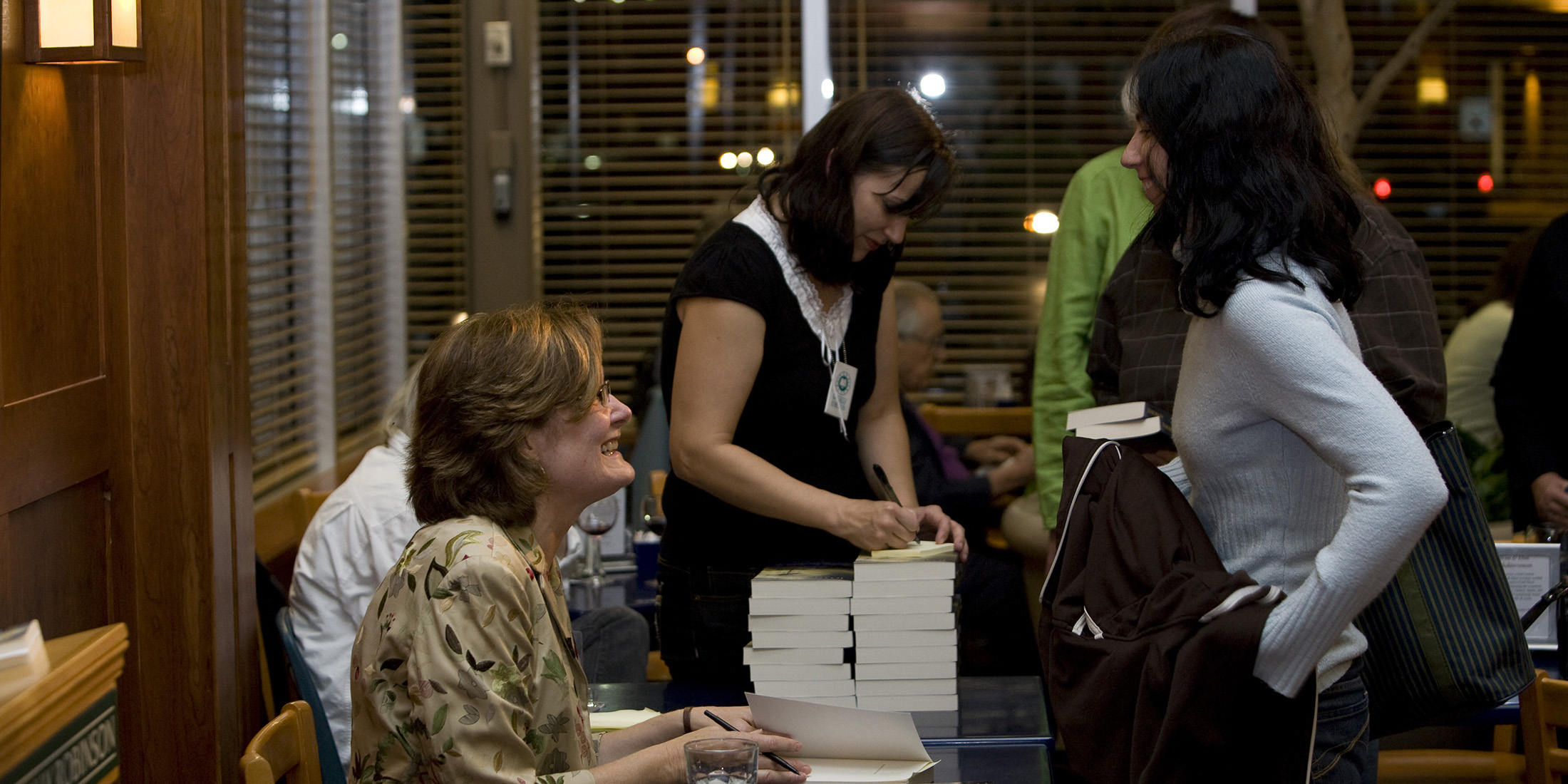 Author Joan Thomas signing books at a launch event